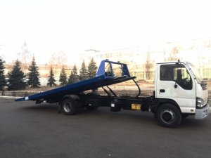 Фото белого эвакуатора с синей платформой.